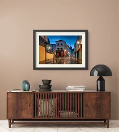 Off the Clock in a dark frame with a white mat above a slatted wood credenza on a taupe wall. (thumbnail 7)