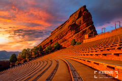Red Rocks Amphitheatre in Morrison, Colorado at sunrise, curved empty rows leading to a towering red sandstone monolith under an orange and violet sky. (thumbnail 3)