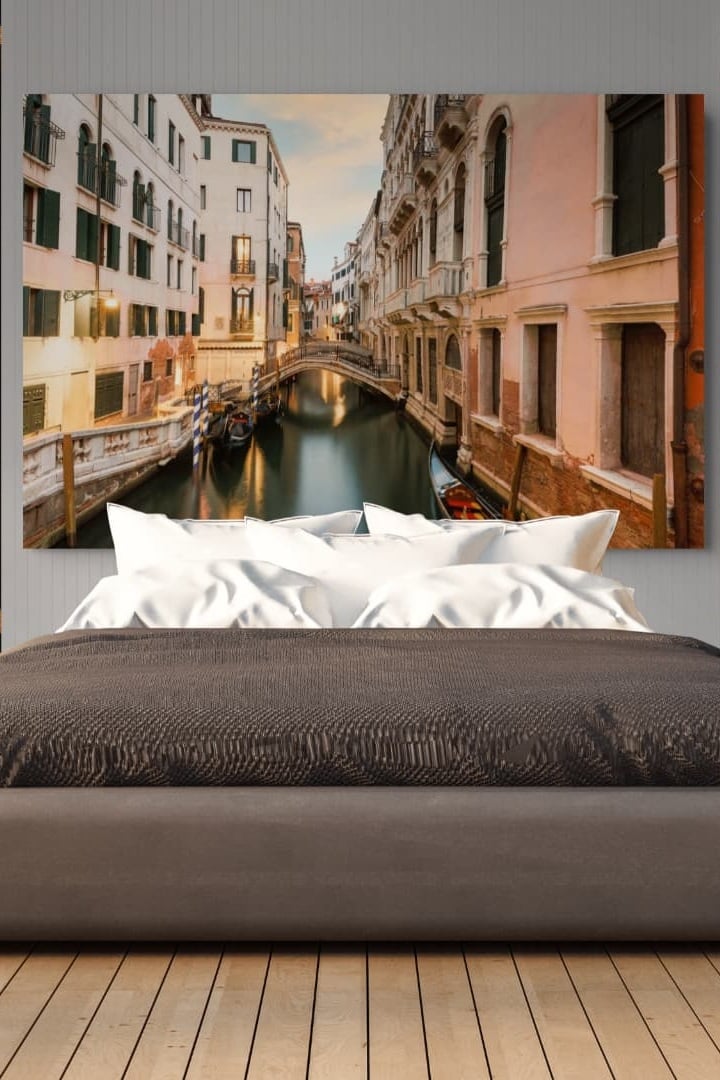 Passing Moment by Sherry Keene shown as a large framed Venice canal print above a bed in a calm, neutral bedroom.